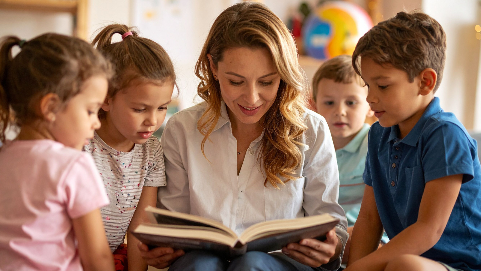 Teacher reading a book to students